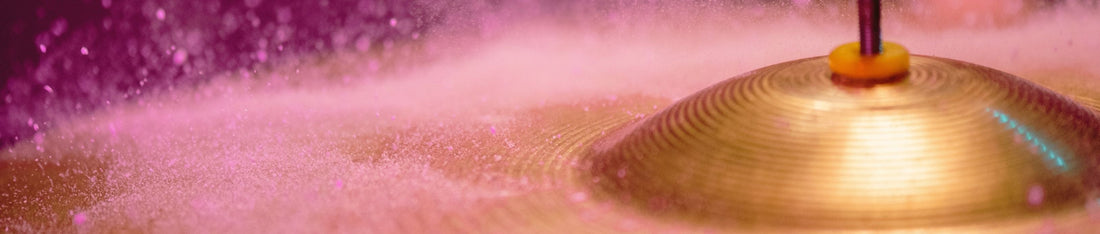 Mor arka plan üzerinde altın rengi zil çanağına çarpan minik su damlacıkları