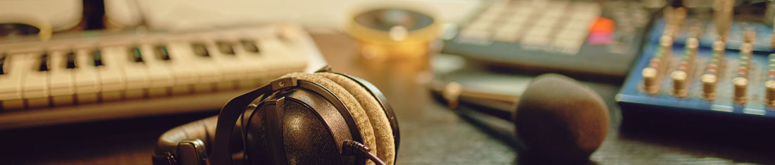 kulak dışı kulaklık ve mikrofon arkasında klavye ve müzik prodüksiyonu için bazı mikser gibi ekipmanlar