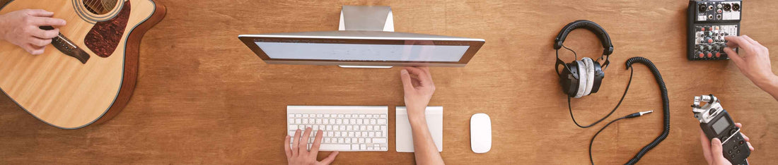 mac bilgisayar gitar ve kulaklık ile müzik yapan müzisyenler yakından çekim