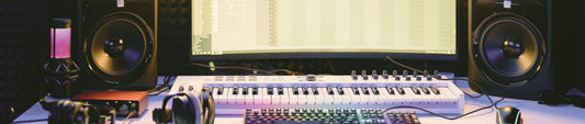 müzik projesi bilgisyar ekranı, hoparlörler ve masada midi klavye ile klavye