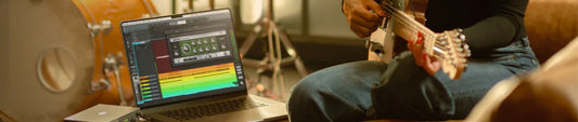 gitar çalarken universal audio LUNA daw kullanan bir müzisyen, gitar ve bilgisayar